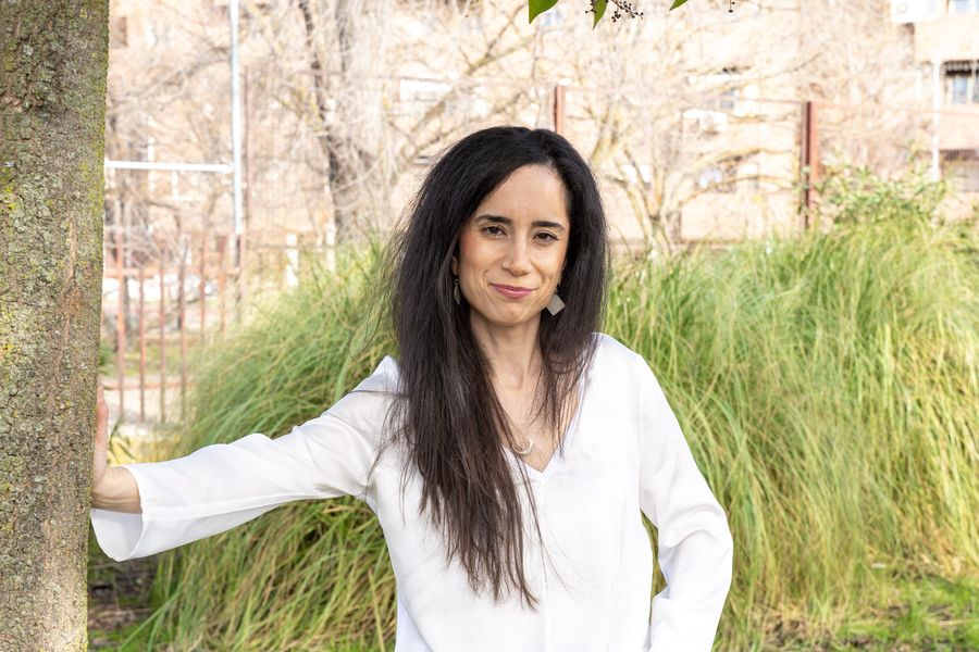 Diana Texeira apoyada en un árbol, en un parque
