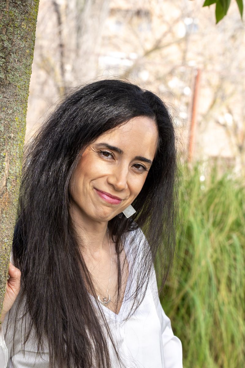 Diana Texeira apoyada en el tronco de un árbol, en un parque